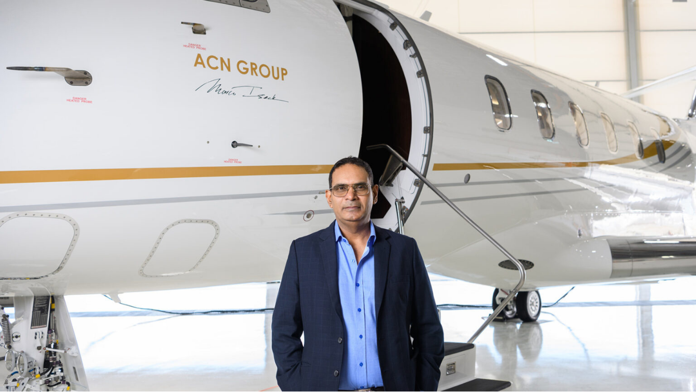 Marco Isaak standing in front of an ACN Group aircraft